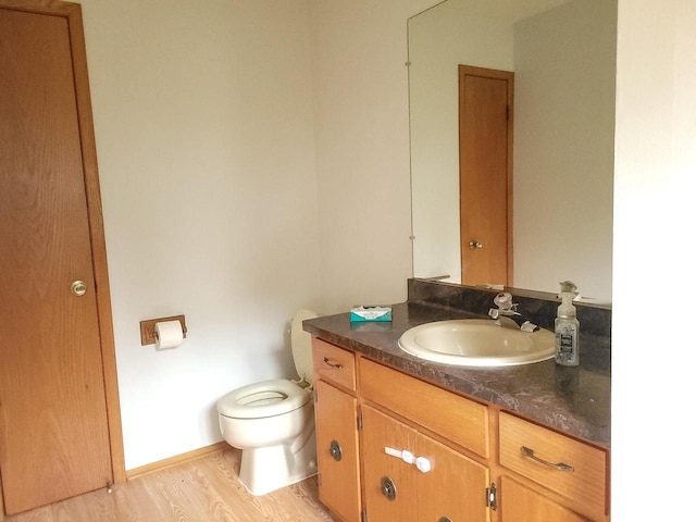 bathroom featuring vanity, wood-type flooring, and toilet