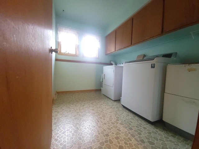 washroom with washer and clothes dryer and cabinets