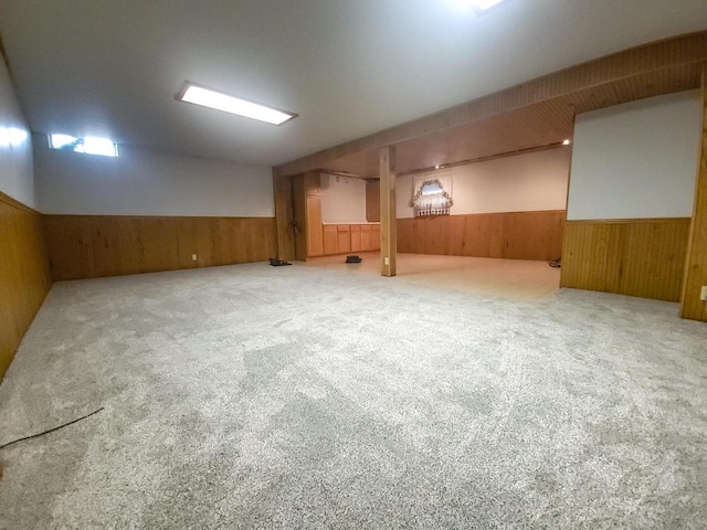 basement featuring carpet and wooden walls