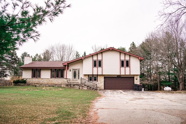 tri-level home with a garage and a front lawn