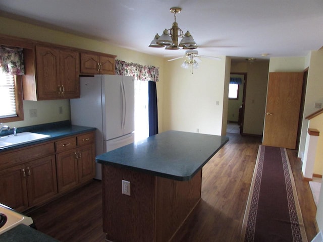 kitchen with a wealth of natural light, sink, a center island, and white fridge