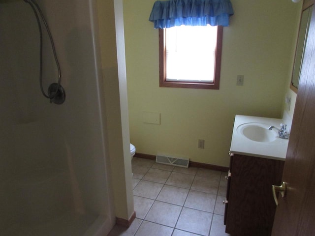 bathroom featuring tile patterned flooring, vanity, toilet, and a shower