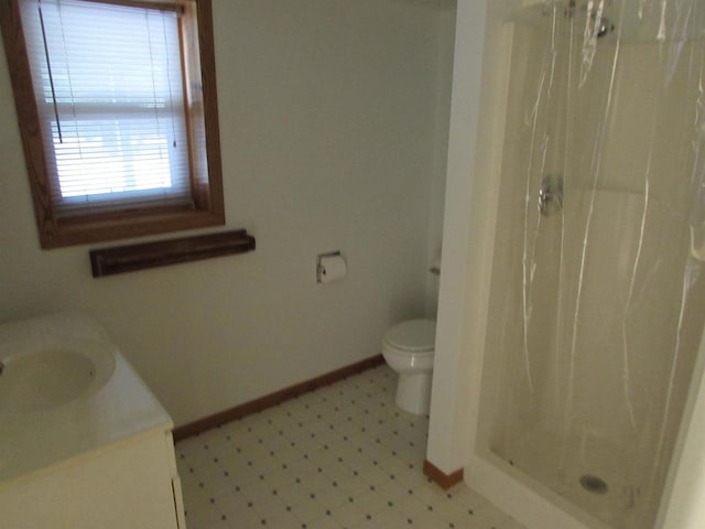 bathroom featuring vanity, toilet, and walk in shower