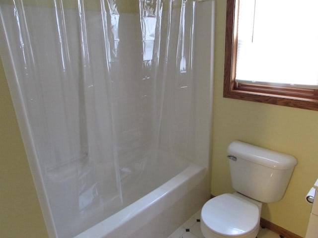 bathroom with tile patterned flooring, shower / tub combo, and toilet