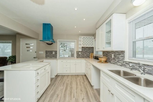 kitchen featuring sink, white cabinets, extractor fan, and light hardwood / wood-style floors