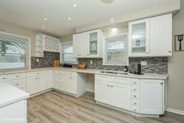 kitchen featuring decorative backsplash, white cabinetry, sink, and light wood-type flooring