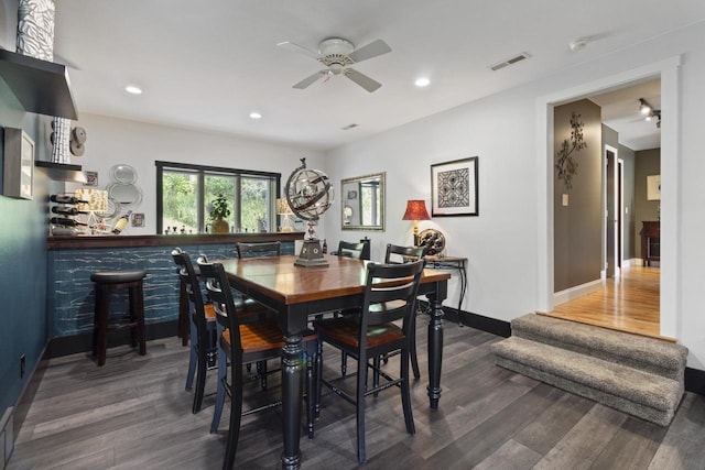 dining area with ceiling fan and dark wood-type flooring