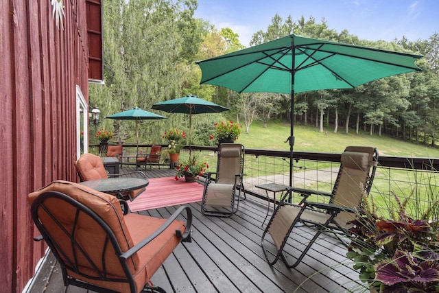 wooden terrace featuring a lawn