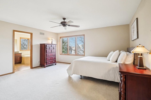 carpeted bedroom with ensuite bath and ceiling fan