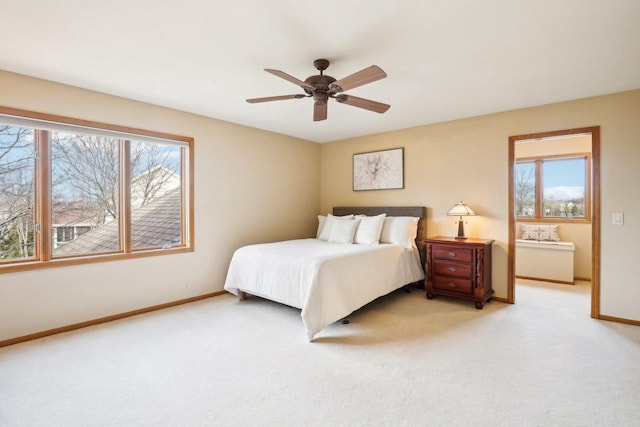 bedroom with ceiling fan, light carpet, and multiple windows