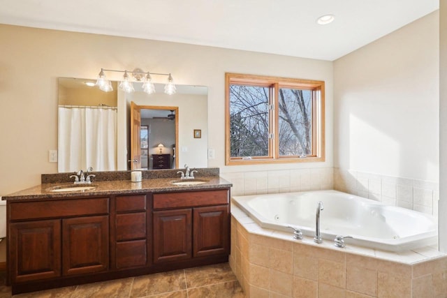 bathroom with vanity and a relaxing tiled tub