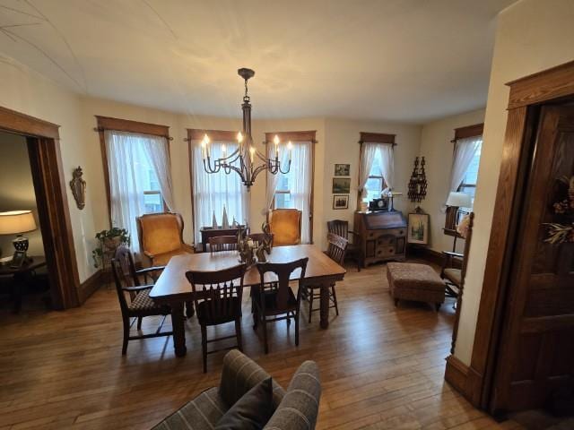 dining area with a chandelier and wood-type flooring