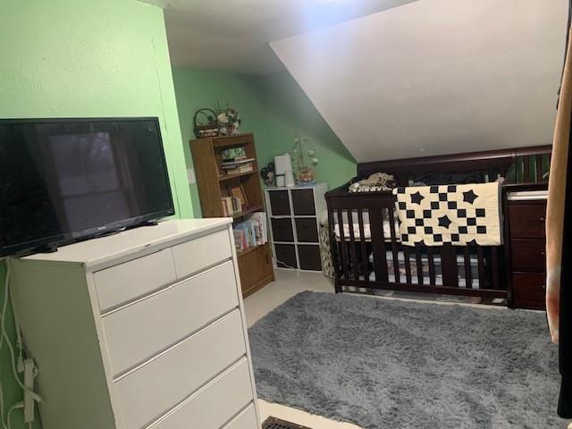 bedroom with a nursery area and vaulted ceiling