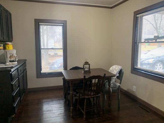 dining space featuring crown molding and dark hardwood / wood-style floors