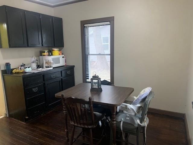 dining area featuring crown molding and dark wood-type flooring