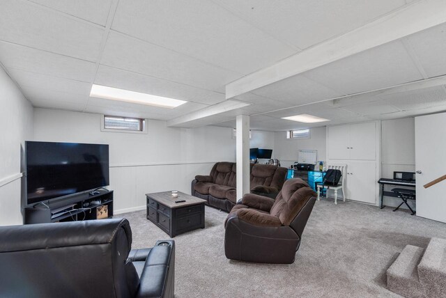 carpeted living room with a drop ceiling