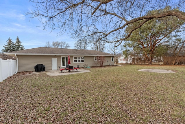 rear view of house featuring a lawn and a patio area