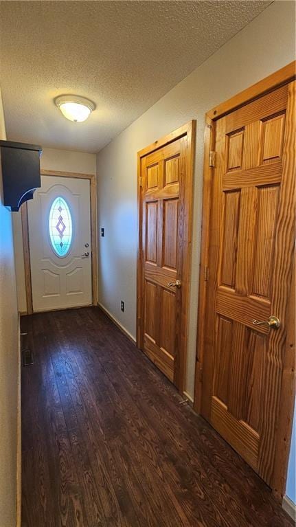 entrance foyer featuring a textured ceiling and dark hardwood / wood-style flooring