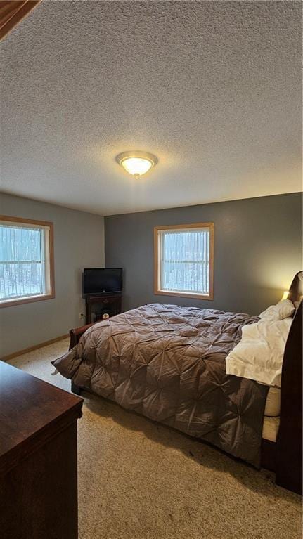 carpeted bedroom featuring a textured ceiling and multiple windows