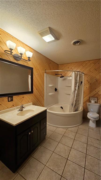 full bathroom featuring shower / tub combo, wood walls, toilet, vanity, and tile patterned floors