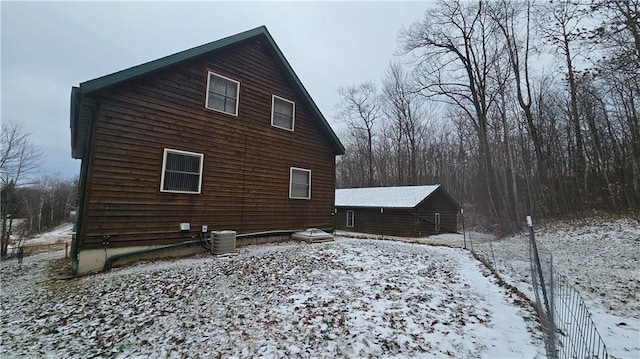 view of snow covered exterior with central AC unit