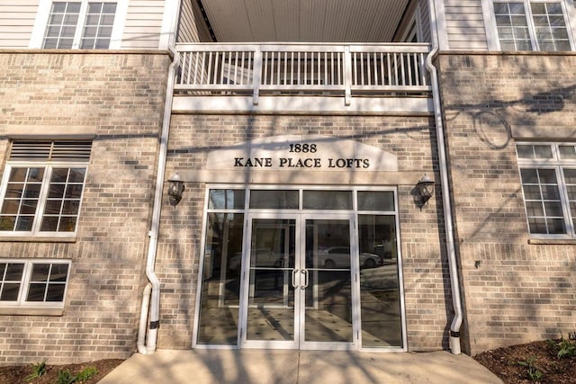 entrance to property featuring a balcony and french doors