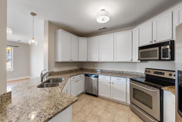 kitchen with appliances with stainless steel finishes, white cabinetry, pendant lighting, and sink