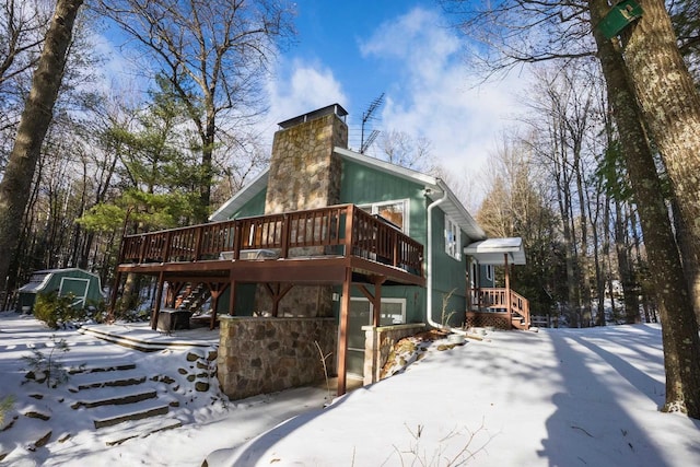 snow covered house featuring a deck