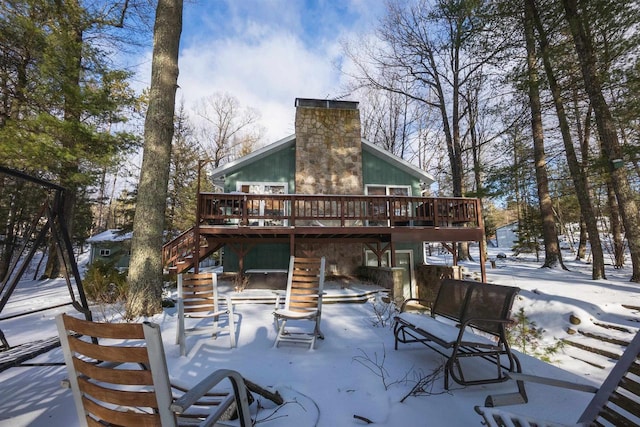 snow covered rear of property featuring a deck