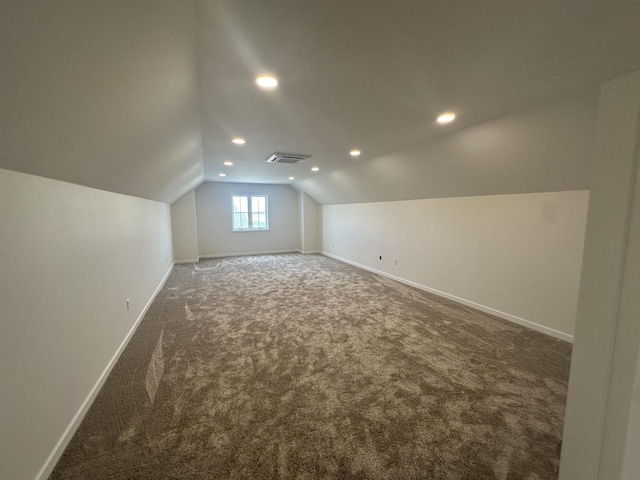 additional living space with carpet flooring, visible vents, recessed lighting, baseboards, and vaulted ceiling