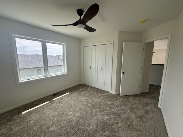 unfurnished bedroom with a closet, baseboards, a ceiling fan, and carpet flooring