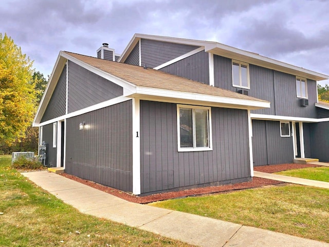 view of side of home with a yard