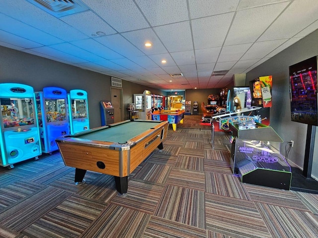 game room with a paneled ceiling, dark colored carpet, and billiards