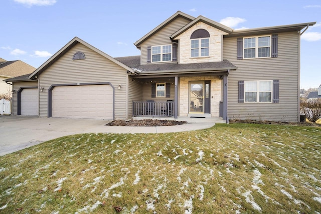 view of property with covered porch, a garage, and a front lawn