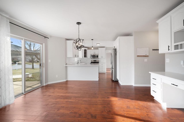 kitchen with hanging light fixtures, a notable chandelier, dark hardwood / wood-style flooring, white cabinetry, and stainless steel appliances