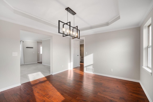 unfurnished dining area with a chandelier, wood-type flooring, a tray ceiling, and crown molding