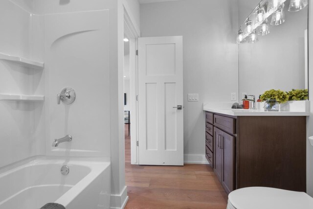 full bathroom with hardwood / wood-style floors, vanity, toilet, and tub / shower combination