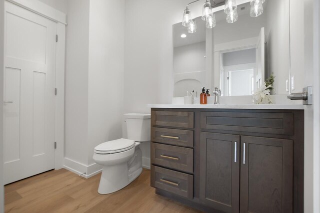 bathroom featuring vanity, wood-type flooring, and toilet