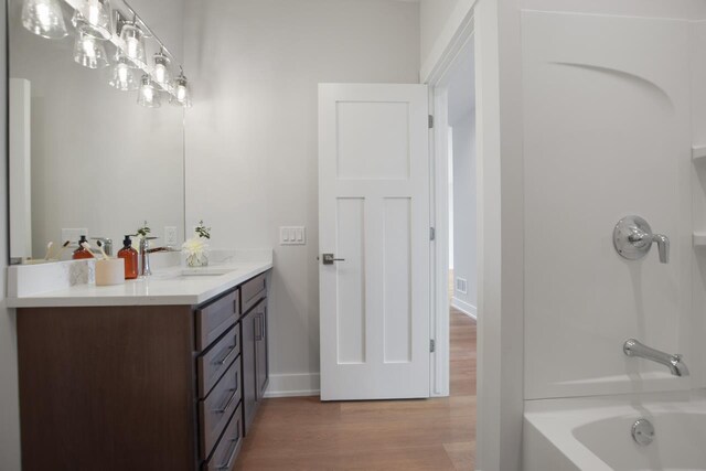 bathroom featuring bathing tub / shower combination, vanity, and hardwood / wood-style flooring