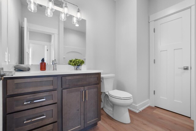 bathroom featuring hardwood / wood-style floors, vanity, and toilet