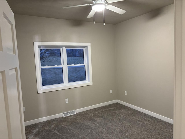 spare room featuring dark colored carpet and ceiling fan