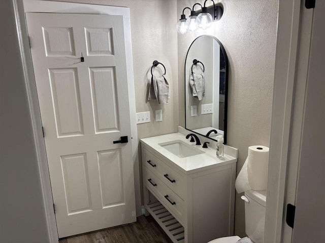 bathroom with vanity, toilet, and wood-type flooring