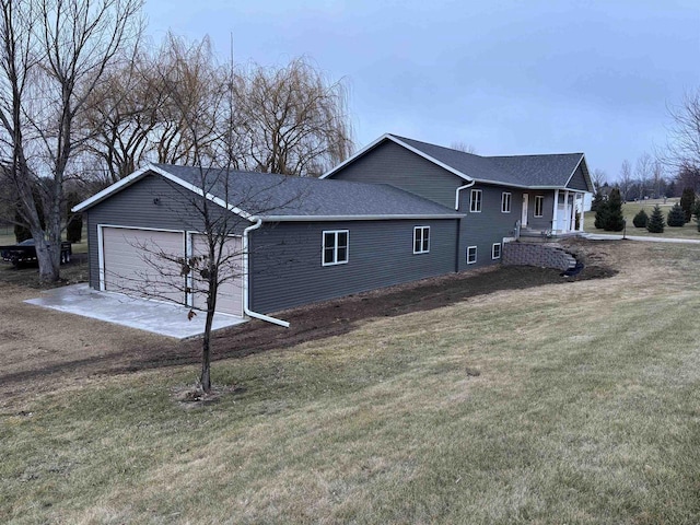 view of side of home with a garage and a lawn