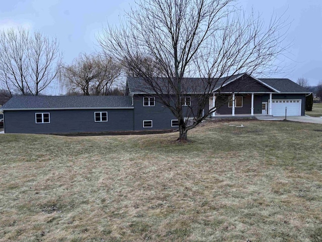 view of front of house with a porch, a garage, and a front lawn