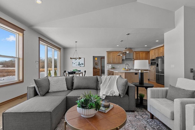 living room featuring light wood-style floors, lofted ceiling, baseboards, and recessed lighting