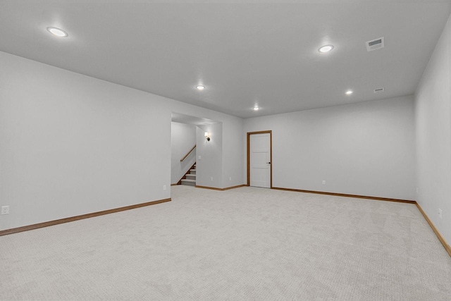 unfurnished room with light carpet, baseboards, stairs, and visible vents