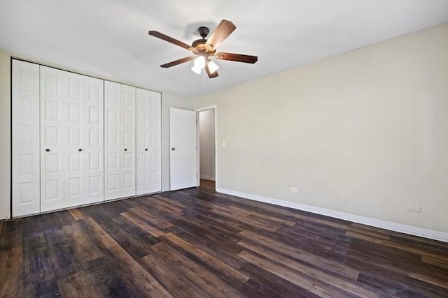 unfurnished bedroom featuring ceiling fan, dark hardwood / wood-style flooring, and a closet