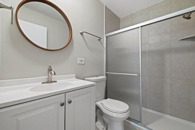 bathroom featuring vanity, toilet, and walk in shower