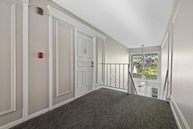 corridor with carpet floors and a chandelier