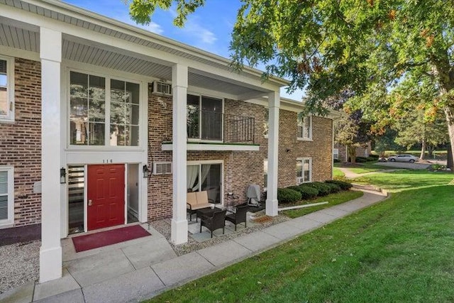 rear view of property with a balcony and a yard